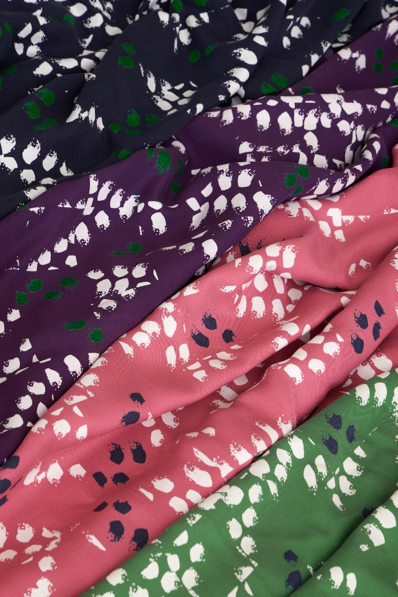 Pu&ograve; includere: Quattro campioni di tessuto con un motivo astratto bianco su sfondo blu scuro, viola, rosa e verde.