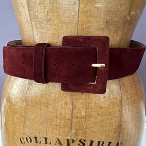 May include: A set of three ceramic mugs with a speckled, cream-colored glaze. Each mug features a different hand-painted floral design in shades of blue, green, and yellow. The mugs have a simple, rounded shape and a comfortable handle.