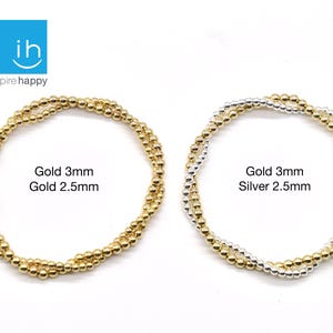 May include: Two beaded bracelets, one gold and one silver, are displayed against a white background. The gold bracelet is labeled "Gold 3mm Gold 2.5mm." The silver bracelet is labeled "Gold 3mm Silver 2.5mm."
