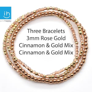 May include: Three beaded bracelets in rose gold and gold tones. The bracelets are made with 3mm beads in a cinnamon and gold mix. The image includes the text "Three Bracelets 3mm Rose Gold Cinnamon & Gold Mix Cinnamon & Gold Mix."