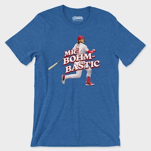 May include: A heather blue short-sleeve t-shirt featuring a graphic of a baseball player in a white pinstripe uniform with a red helmet and bat. The text MR BOHM-BASTIC is printed in large red letters across the center of the chest area.