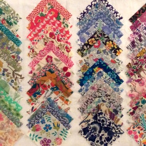 Pode incluir: Uma coleção de 40 quadrados de tecido com vários padrões florais em tons de verde, rosa, azul e roxo. Os quadrados estão dispostos em quatro filas de dez, com cada fila apresentando um esquema de cores diferente.