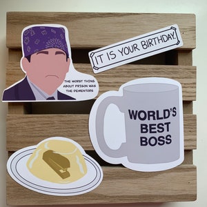 May include: A set of four vinyl stickers featuring pop culture references: a character in a purple bandana with the text THE WORST THING ABOUT PRISON WAS THE DEMENTORS, a rectangular banner reading IT IS YOUR BIRTHDAY, a mug saying WORLD'S BEST BOSS, and a stapler inside yellow gelatin.