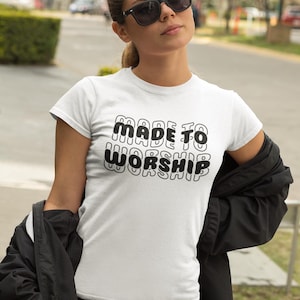 Puede incluir: Camiseta blanca con texto negro que dice "MADE TO WORSHIP" en una fuente retro.