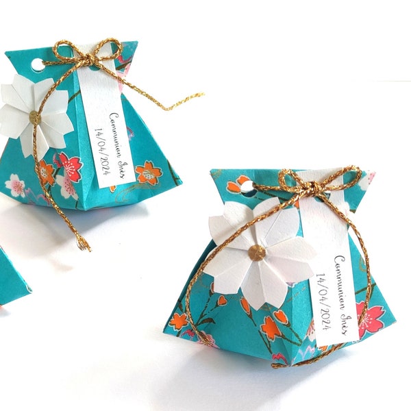 Set of cherry blossom favor boxes on a turquoise background for wedding baptism table decoration, birthday guest gift