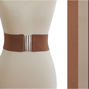 May include: A brown elastic belt with a silver buckle. The belt is shown on a white mannequin. The image also shows three different colors of the belt: brown, beige, and dark brown.