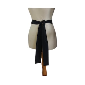 May include: A black fabric belt tied in a bow at the front. The belt is worn on a white dress form.
