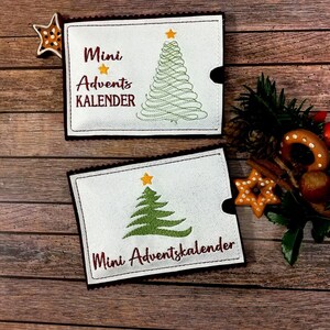 May include: Two white felt Christmas advent calendar pouches with embroidered green Christmas trees and the text "Mini Advent Kalender" and "Mini Adventskalender".