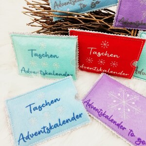 May include: Five felt pouches with different colors and designs. Each pouch has the text "Taschen Adventskalender" embroidered on it. The pouches are perfect for creating a unique advent calendar.
