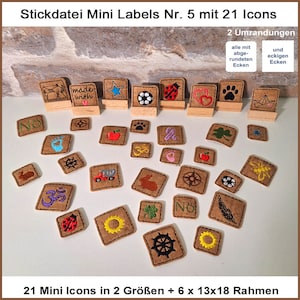 May include: A set of 21 embroidery designs for mini labels, featuring various icons like a paw print, a heart, a star, a sunflower, a ladybug, a compass, a car, a rabbit, a clover, a footprint, a ship, a feather, a  'No' sign, and an Om symbol. The designs are available in two sizes and come with six 13x18 frames. The designs are all embroidered on a brown fabric background.