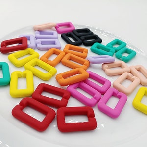 May include: Assortment of colorful plastic rectangle-shaped beads. The beads are in various colors, including red, orange, yellow, green, blue, purple, pink, and black.