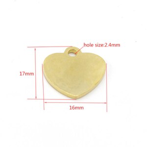 May include: Gold heart-shaped metal tag with a hole for a chain or cord. The tag measures 1.6 inches wide and 1.7 inches tall. The hole is 0.24 inches in diameter.