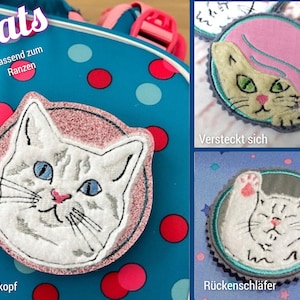 Könnte beinhalten: Drei runde Stickaufnäher mit Katzenmotiven. Einer zeigt einen weißen Katzenkopf mit blauen Augen auf rosa Grund, ein anderer einen Katzenkopf mit rosa Haar und der dritte eine weiße Katze mit erhobenen Pfoten. Text: Cats, Passend zum Ranzen, Versteckt sich, Katzenkopf, Rückenschläfer.