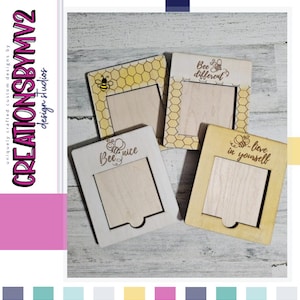 May include: Four wooden picture frames with a honeycomb pattern and bee-themed quotes. The quotes are "Bee different", "Bee nice", and "Bee lieve in yourself".