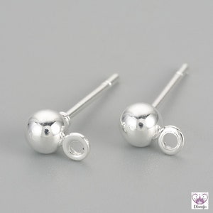 May include: Two silver earring posts with a small round ball at the top and a jump ring attached to the ball.