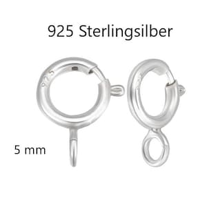Pode incluir: Duas fechos de anel de mola em prata esterlina 925. Um fecho está aberto e o outro está fechado. Os fechos têm 5 mm. O texto "925 Sterlingsilber" está acima dos fechos.