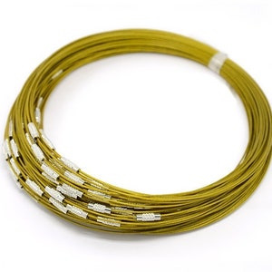 Könnte beinhalten: Nahaufnahme einer goldfarbenen Metalldrahtkette. Die Kette ist aufgerollt und scheint aus mehreren Drahtsträngen zu bestehen.