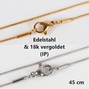 May include: Two gold and silver chains with lobster clasps. The gold chain is labelled "Edelstahl & 18k vergoldet (IP)". The silver chain is 45 cm long.