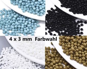 May include: Assortment of 4 x 3 mm round glass beads in four colors: turquoise, black, white, and brown. The beads are displayed on white plates.