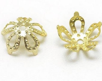 May include: Two gold metal flower-shaped bead caps with a decorative design. The caps have a round hole in the center and are designed to be used for jewelry making.