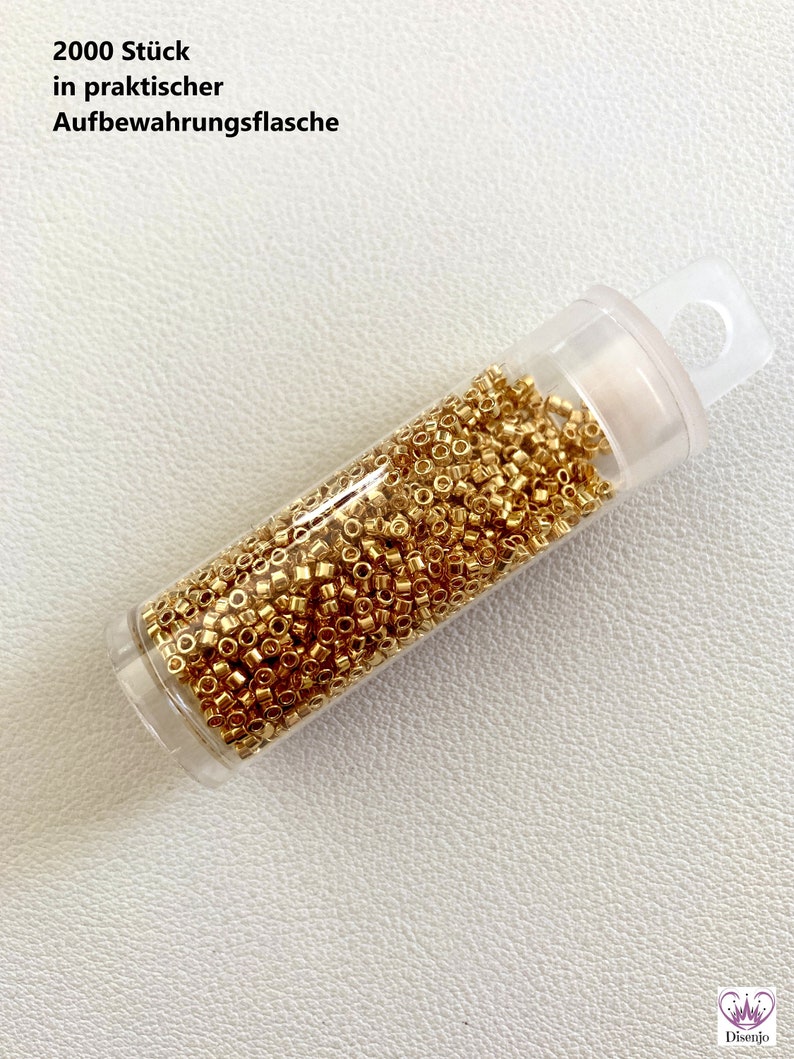 May include: A clear plastic bottle filled with 2000 gold-colored beads. The bottle has a label that reads "2000 St&uuml;ck in praktischer Aufbewahrungsflasche".