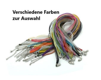 Puede incluir: Una colección de cordones de cinta de colores con cierres plateados. Los cordones de cinta están hechos de tela transparente y vienen en una variedad de colores, incluyendo negro, blanco, rosa, azul, verde y amarillo. El texto "Verschiedene Farben zur Auswahl" es visible en la imagen.