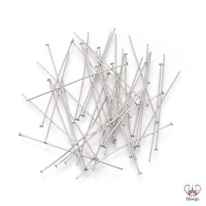 Puede incluir: Un mont&oacute;n de alfileres de cabeza plateados, utilizados para la elaboraci&oacute;n de joyas y manualidades.