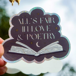 May include: A holographic sticker with a cloud shape and a book with a crescent moon. The sticker says "All's fair in love & poetry".