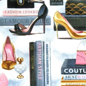 Könnte beinhalten: Ein Stoffdesign mit Illustrationen von High Heels, Handtaschen und Büchern mit Titeln wie "Fashion Lookbook" und "Parisian Style". Die Farbpalette umfasst Schwarz, Gold, Rosa und Weiß und schafft ein stilvolles und glamouröses Thema.