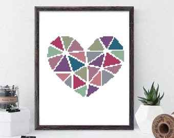 Puede incluir: Un patrón de punto de cruz enmarcado de un corazón hecho de formas geométricas coloridas. El corazón está hecho de varios tonos de rosa, morado, azul y verde.