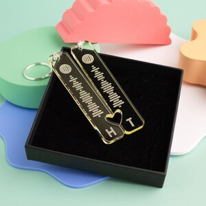 May include: Two clear acrylic keychains with a heart and the letters "H" and "T" engraved on them. The keychains are engraved with a sound wave pattern and have a silver key ring.