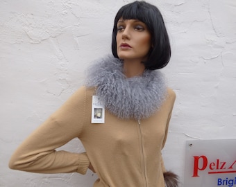 May include: A tan sweater with a zipper closure and a gray faux fur collar. The sweater has a tag that says "Pelz Art" on it.