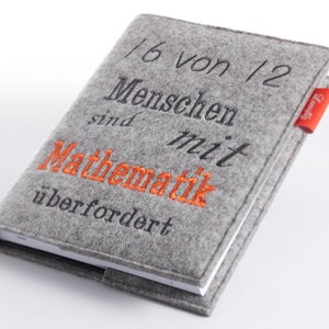 Könnte beinhalten: Grauer Filz-Notizbuchumschlag mit dem gestickten Text "1/6 von 1/2 Menschen sind mit Mathematik überfordert" in Schwarz und Orange.