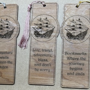 May include: Set of six wooden bookmarks with a ship design and inspirational quotes. The bookmarks have a tassel on the top and are made of natural wood.