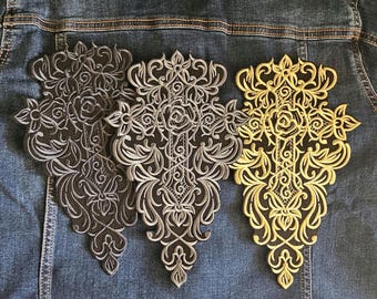 Puede incluir: Tres parches bordados con diseños florales ornamentados. Un parche es dorado, otro plateado y otro gris oscuro. Los parches están sobre una chaqueta vaquera.