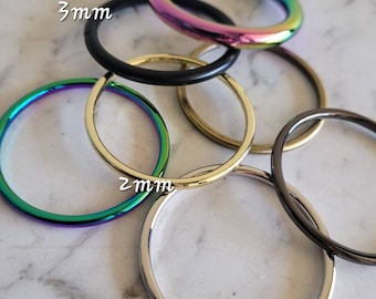 Puede incluir: Un conjunto de seis anillos metálicos de diferentes tamaños, incluyendo 2 mm, 3 mm y 5 mm. Los anillos son todos iridiscentes y tienen un acabado arcoíris.