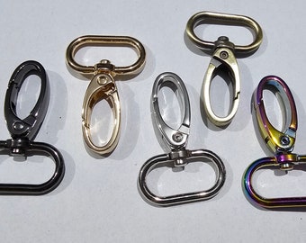 Puede incluir: Cinco cierres giratorios de metal en varios acabados. Los cierres son de forma ovalada con una puerta de resorte. Los acabados incluyen negro, dorado, plateado e iridiscente.