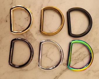 Puede incluir: Seis anillos en D de metal en diferentes acabados: dorado, latón, negro, níquel, plateado e iridiscente.