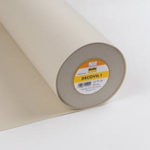 May include: A roll of beige Decovil I fabric, partially unrolled, showing a cylindrical core with a yellow and orange label. The fabric looks smooth and robust, suitable for various craft projects.
