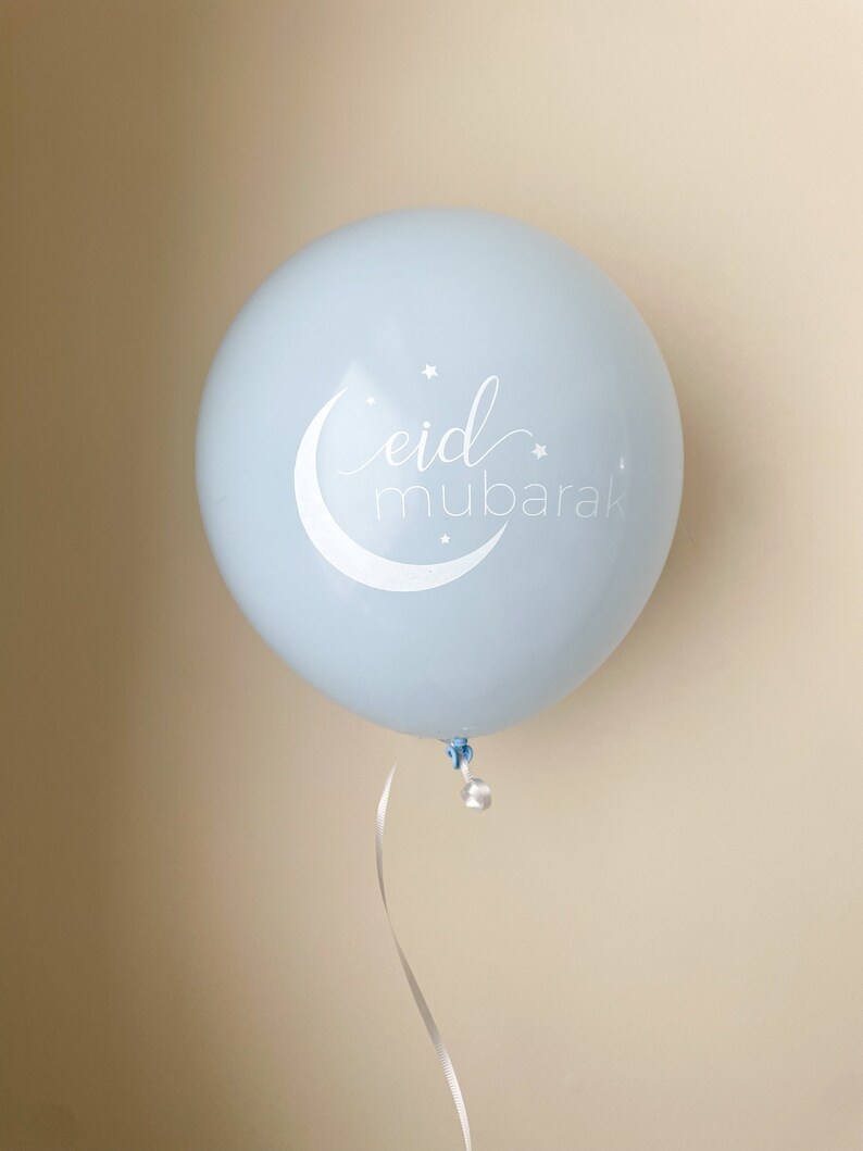 May include: A light blue balloon with a white crescent moon and stars, and the text "eid mubarak" in white cursive lettering.