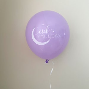 May include: A purple balloon with a white crescent moon and stars, and the text "eid mubarak" in white cursive.