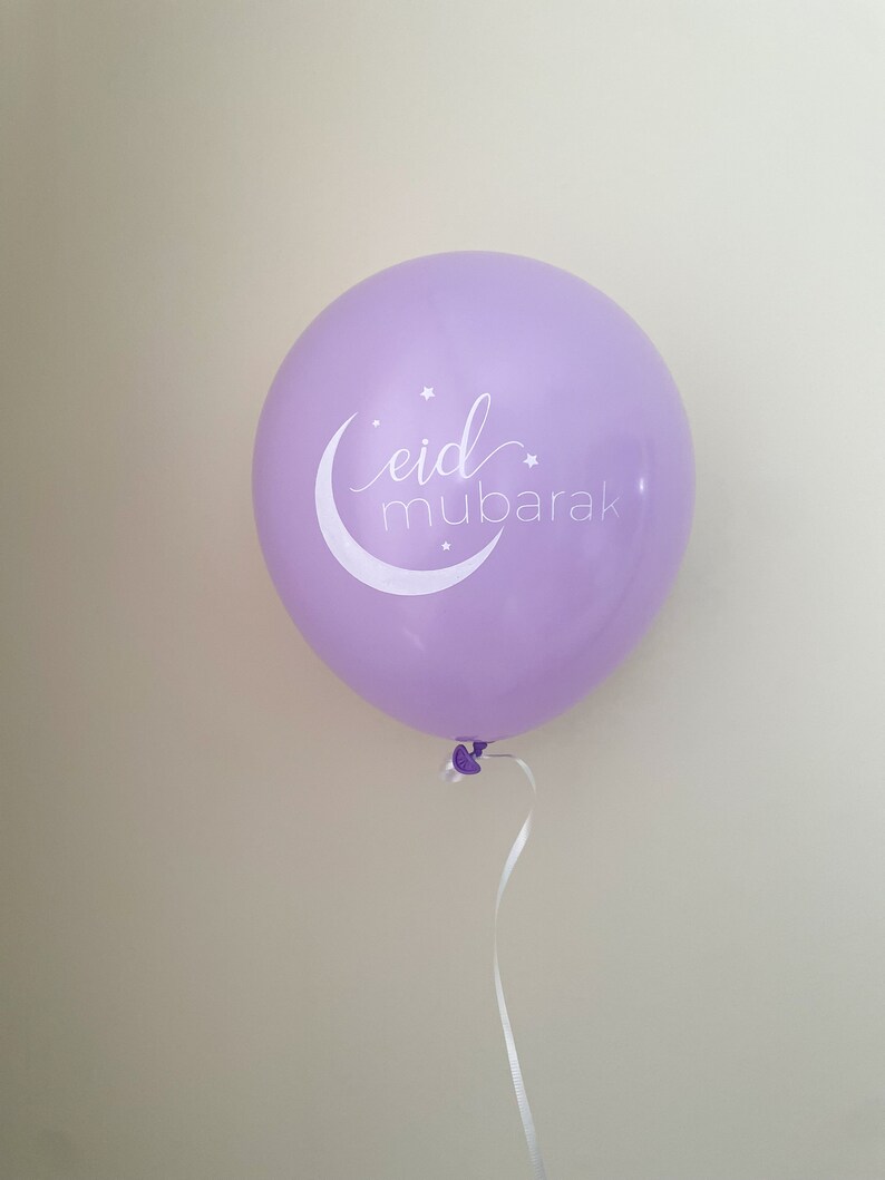 May include: A purple balloon with a white crescent moon and stars, and the text "eid mubarak" in white cursive.