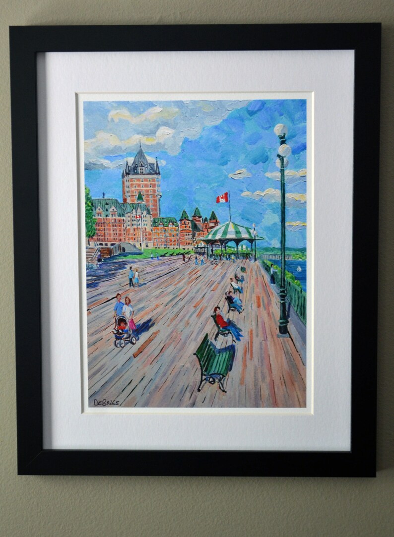 May include: A framed painting of a waterfront scene with a large building in the background, a boardwalk in the foreground, and people walking and sitting on benches. The sky is blue with white clouds. The painting is signed "DeBaise".