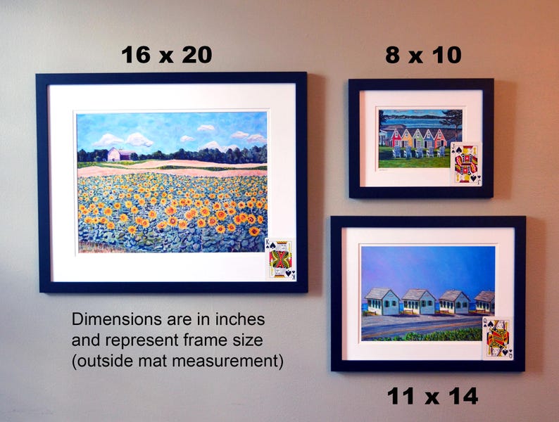 May include: Three framed paintings with different scenes. The top left painting is a landscape with a field of sunflowers, the top right painting shows a row of colorful beach houses, and the bottom right painting shows a row of white beach houses. The dimensions of the frames are listed below each painting.