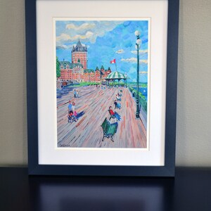 May include: A framed painting of a waterfront scene with a large building in the background. The painting is done in a colorful, impressionistic style. The building is red and white and has a green roof. There are people walking on the boardwalk in front of the building. The sky is blue with white clouds. The painting is signed "DeBaise" in the lower left corner.