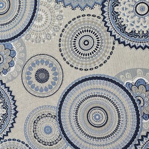 Può includere: Primo piano di un tessuto con un motivo ripetuto di disegni mandala circolari blu, blu navy e grigi. I mandala variano per dimensioni e dettagli, con motivi e bordi intricati. Lo sfondo è di colore beige neutro.