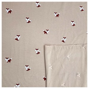 Pu&ograve; includere: Tessuto beige con un motivo ripetuto di piccole volpi rosse. Il tessuto &egrave; piegato a met&agrave;, con il lato a motivi rivolto verso l'alto.