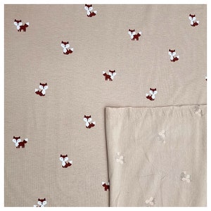 Pu&ograve; includere: Tessuto beige con un motivo ripetuto di piccole volpi rosse. Il tessuto &egrave; piegato a met&agrave;, con il lato a motivi rivolto verso l'alto.