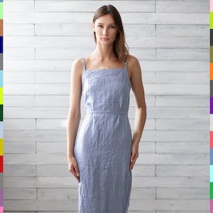 May include: A light blue linen dress with thin straps and a tie belt. The dress is midi length and has a relaxed fit.