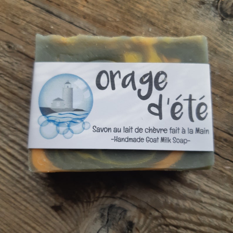 Puede incluir: Una pastilla de jab&oacute;n artesanal de leche de cabra con un patr&oacute;n de remolino en tonos verdes y amarillos. El jab&oacute;n est&aacute; etiquetado como "orage d'&eacute;t&eacute;" y "Savon au lait de ch&egrave;vre fait &agrave; la Main -Handmade Goat Milk Soap-"